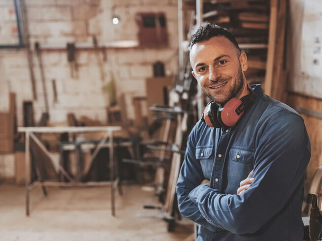 Construction worker smiling in a wood shop