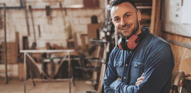 Construction worker smiling in a wood shop